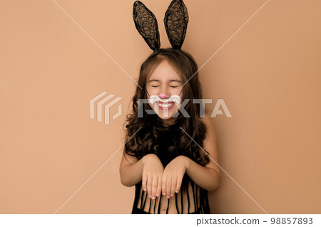 Funny laughing girl with bunny ears and a painted face. The rabbit is a symbol of Easter 98857893