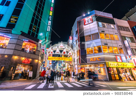 日本東京市景，池袋站西出口，西一大道。喜歡智能手機遊戲（左手反复敲擊）和優步自行車送貨的老年人 98858046