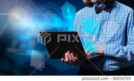 Young male using laptop for texting, communication, learning, information storage. Young male using laptop for texting, communication, learning, information storage. 98858704