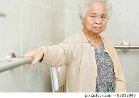 Asian elderly old woman patient use toilet support rail in bathroom, handrail safety grab bar, security in nursing hospital. Asian elderly old woman patient use toilet support rail in bathroom, handrail safety grab bar, security in nursing hospital. 98858940