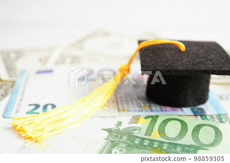 Graduation gap hat on Euro and US dollar banknotes money, Education study fee learning teach concept. 98859305