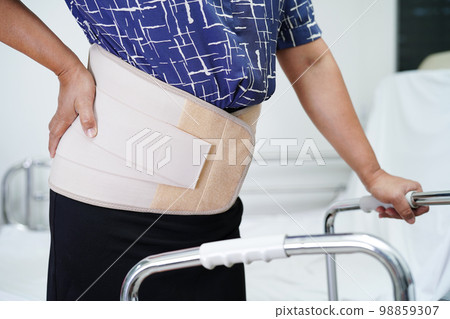 Asian senior pain back wearing elastic support belt with walker. Asian senior pain back wearing elastic support belt with walker. 98859307