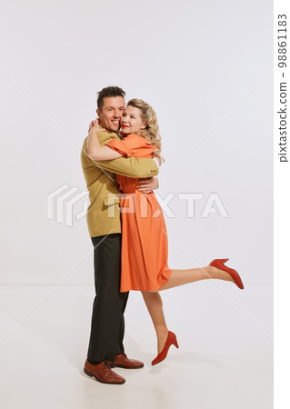 Young happy man and woman, family couple in retro style clothes hugging isolated over light background. Concept of love, relationship, retro style, creativity, family. Young happy man and woman, family couple in retro style clothes hugging isolated over light background. Concept of love, relationship, retro style, creativity, family. 98861183