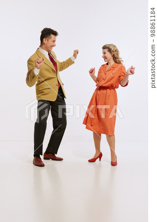 Stylish smiling man and woman in retro style clothes dancing twist dance isolated over white background. Concept of love, relationship, retro style, creativity, family. Stylish smiling man and woman in retro style clothes dancing twist dance isolated over white background. Concept of love, relationship, retro style, creativity, family. 98861184