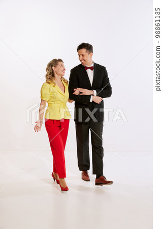 Happy young man and woman, loved couple in retro style clothes walking isolated over white background. Concept of love, relationship, retro style, creativity, family. 98861185