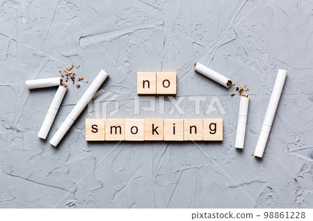 Cigarette And Wooden Blocks, Broken cigarette on table background, No Tobacco Day with hourglass, clock health concept. time to quit smoking 98861228