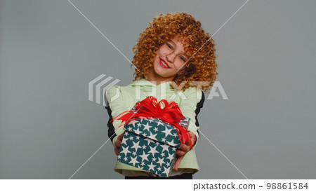 Lovely smiling teen child girl kid presenting birthday gift box offer wrapped present celebrating 98861584