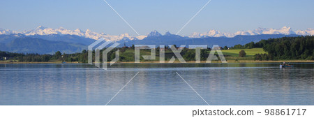 Shore of Lake Pfaffikon in spring, Wetzikon and snow capped mountains. 98861717