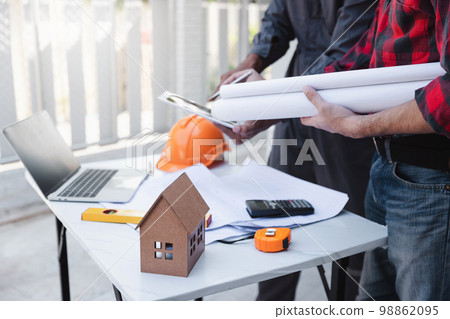 Construction concept of Engineer and Architect working at Construction Site with blue print, Engineer and Architect discussing construction plan with computer laptop calculator 98862095
