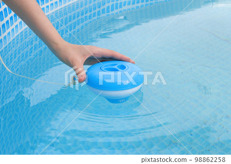 Worker hands isinfection and chlorination of water in the pool. Purification from pollution pool chlor dispenser 98862258