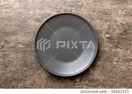 Top view of black plate on cement background. Empty space for your design Top view of black plate on cement background. Empty space for your design 98862315