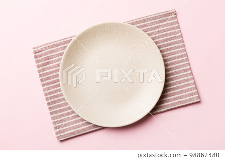 Top view on colored background empty round white plate on tablecloth for food. Empty dish on napkin with space for your design 98862380