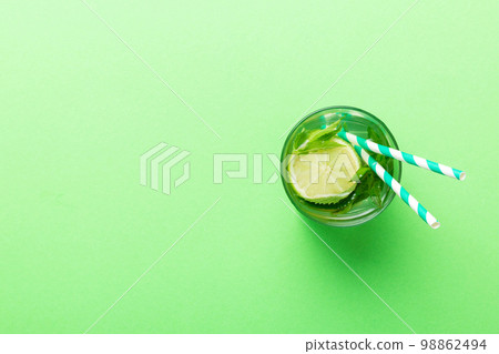 Caipirinha, Mojito cocktail, vodka or soda drink with lime, mint and straw on table background. Refreshing beverage with mint and lime in glass top view flat lay Caipirinha, Mojito cocktail, vodka or soda drink with lime, mint and straw on table background. Refreshing beverage with mint and lime in glass top view flat lay 98862494