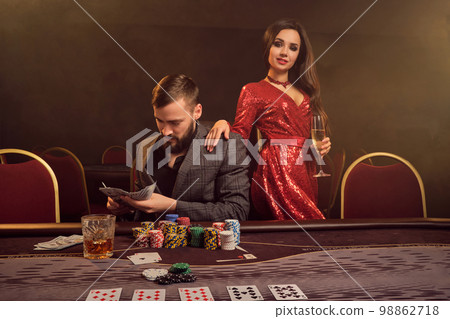 Charming wealthy couple are playing poker at a casino. 98862718