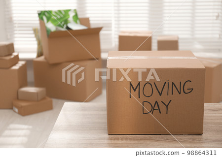 Cardboard box with words MOVING DAY on wooden table Cardboard box with words MOVING DAY on wooden table 98864311
