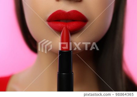 Woman with red lipstick on pink background, closeup Woman with red lipstick on pink background, closeup 98864365