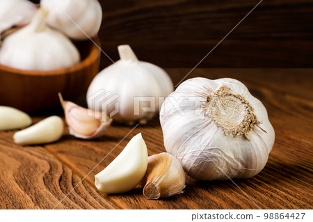 Head of garlic with cloves on a wooden background. 98864427