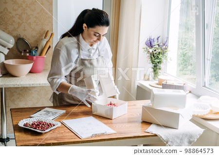 Bakery small local business. Specialty cakes for weddings, birthdays and anniversaries. Female Confectioner baker make cake in kitchen Bakery. 98864573