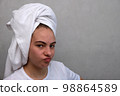 A teenage girl twisted her face, which she does not like because of acne. Acne. 98864589