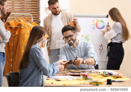 Fashion designers creating new clothes in studio Fashion designers creating new clothes in studio 98865998