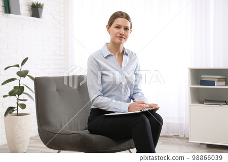 Professional psychotherapist with clipboard in modern office Professional psychotherapist with clipboard in modern office 98866039