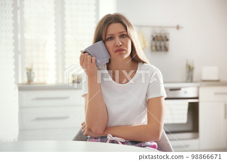 Sleepy young woman with cup of drink at home in morning 98866671