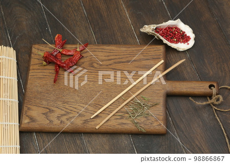 empty wooden kitchen board with hot chili pepper, Japanese sticks, sea shell and copy space 98866867