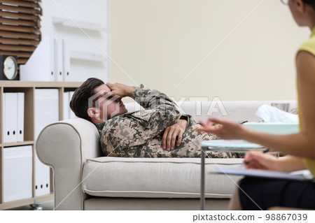 Male military officer having appointment with psychotherapist in office Male military officer having appointment with psychotherapist in office 98867039