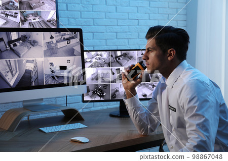 Male security guard with portable transmitter at workplace Male security guard with portable transmitter at workplace 98867048