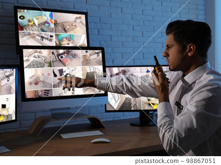 Male security guard with portable transmitter at workplace Male security guard with portable transmitter at workplace 98867051
