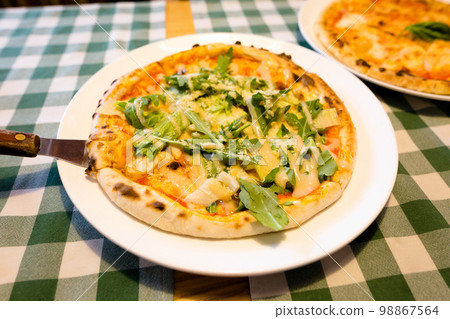Fresh homemade authentic italian stone oven caesar pizza with arugula, sauce, grilled chicken, herbs and spicy parmesan cheese and margherita. Fresh homemade authentic italian stone oven caesar pizza with arugula, sauce, grilled chicken, herbs and spicy parmesan cheese and margherita. 98867564