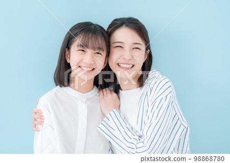 Good friends, mother and daughter, blue background Good friends, mother and daughter, blue background 98868780