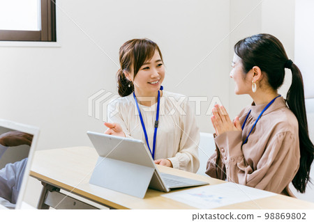 Business woman teaching young staff in company office / conference room (education / training / Asian / Japanese / Chinese) Business woman teaching young staff in company office / conference room (education / training / Asian / Japanese / Chinese) 98869802