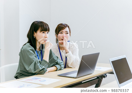 A business woman who goesssips, gossips, and speaks ill of her in the company's office/meeting room A business woman who goesssips, gossips, and speaks ill of her in the company's office/meeting room 98870337