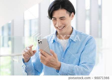 A young office casual businessman who operates a smartphone Photography cooperation "LINK FOREST" 98871366