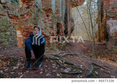 A teenager sits in an old abandoned house. A teenager sits in an old abandoned house. 98873106