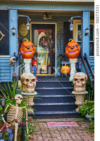 Pumpkins and skeletons for Halloween decorate exterior of American house porch in New York Pumpkins and skeletons for Halloween decorate exterior of American house porch in New York 98873331