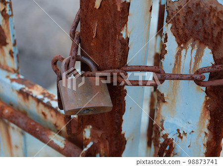 Security image: old padlock locked on rusty door 98873741