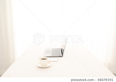 A laptop on a white table, a smartphone, and a coffee cup (coffee cup pinto) A laptop on a white table, a smartphone, and a coffee cup (coffee cup pinto) 98876591