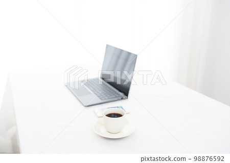 A laptop on a white table, a smartphone, and a coffee cup (coffee cup pinto) A laptop on a white table, a smartphone, and a coffee cup (coffee cup pinto) 98876592