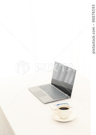 A laptop on a white table, a smartphone, and a coffee cup (coffee cup pinto) A laptop on a white table, a smartphone, and a coffee cup (coffee cup pinto) 98876593