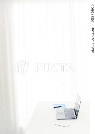 A laptop, a smartphone, and a document on a white table 98876609