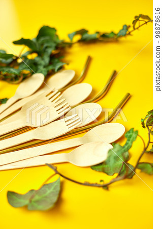 Flat lay reusable stainless steel straws and eco wooden spoons Flat lay reusable stainless steel straws and eco wooden spoons 98878616