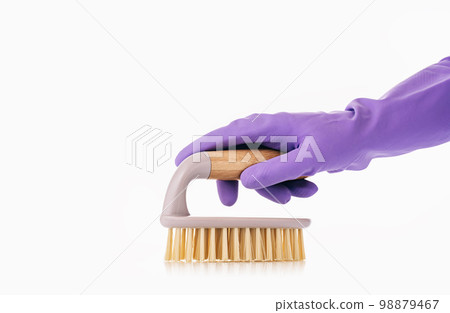 Hand in glove dusting or brushing on white. Household Cleaning tools and sundry items Spring cleaning kitchen, bathroom and other rooms. Cleaning service concept. vibrant violet 98879467