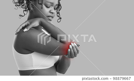 Young African American woman suffering from elbow pain due to arthritis or arm injury 98879667