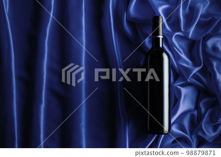 Bottle of red wine on a satin background. Bottle of red wine on a satin background. 98879871