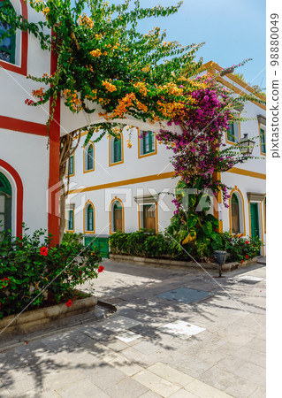 historic center of puerto de mogan with lots of bougainvillea flowers, Canary Island 98880049