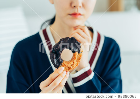 A young woman worried about donuts A young woman worried about donuts 98880065