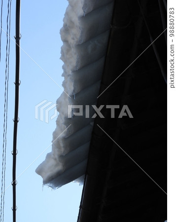 Snow cornice sticking out of the roof Snow cornice sticking out of the roof 98880783