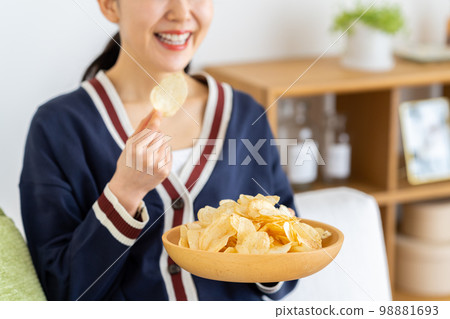 一個吃薯片的年輕女人 一個吃薯片的年輕女人 98881693